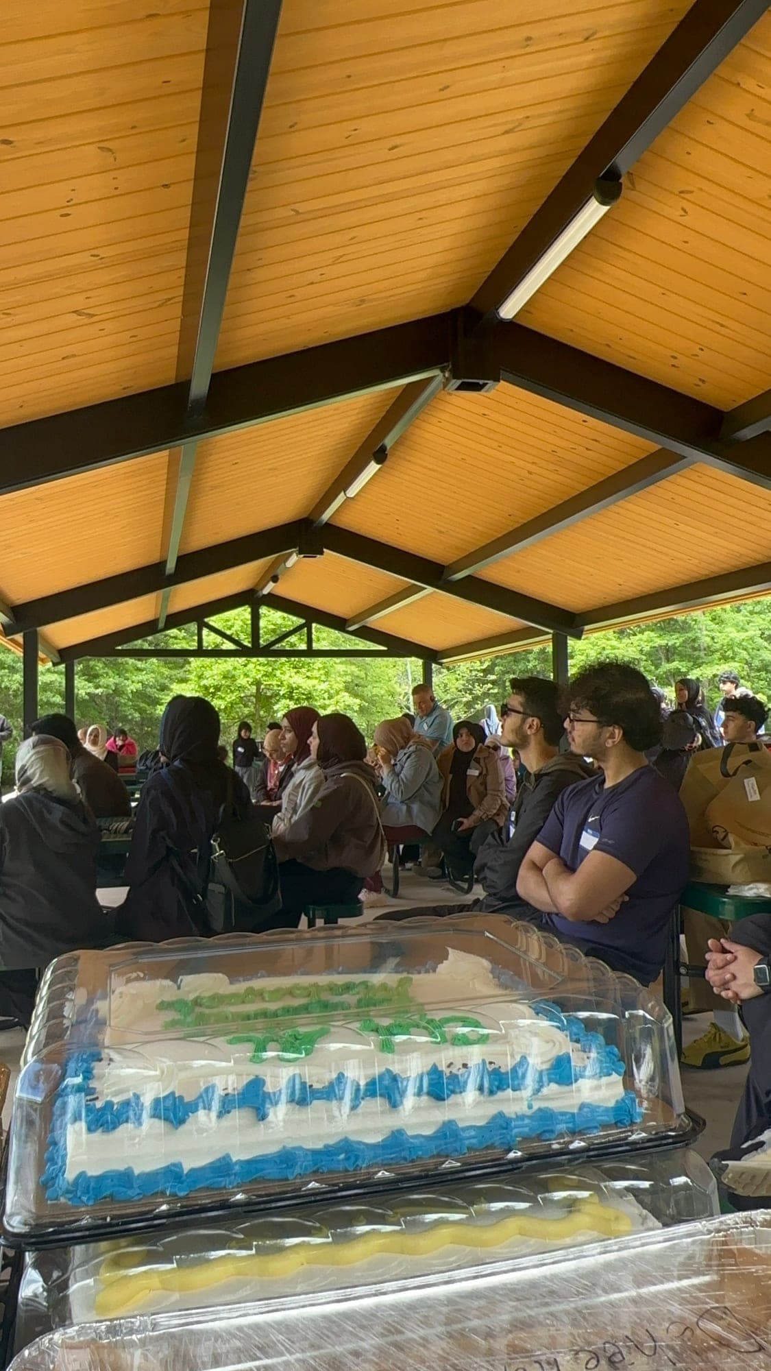 Community members gathered under a park pavilion on an outdoor trip